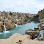 view of the Shushtar Historical Hydraulic System, featuring cascading waterfalls, ancient water mills along the Karun River